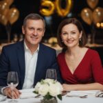 Elegancka para świętuje 50. urodziny przy udekorowanym stole w restauracji, uśmiechnięci i zrelaksowani.